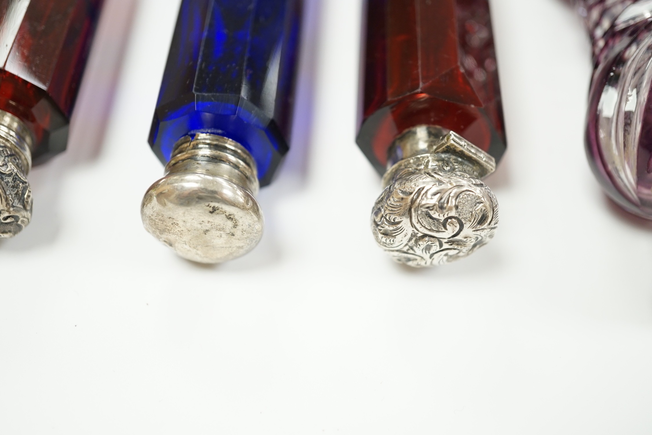Six assorted late 19th/early 20th century white metal mounted coloured glass double ended scent bottles including pale green, 14.9cm and amethyst flash, 13.7cm (some a.f.)